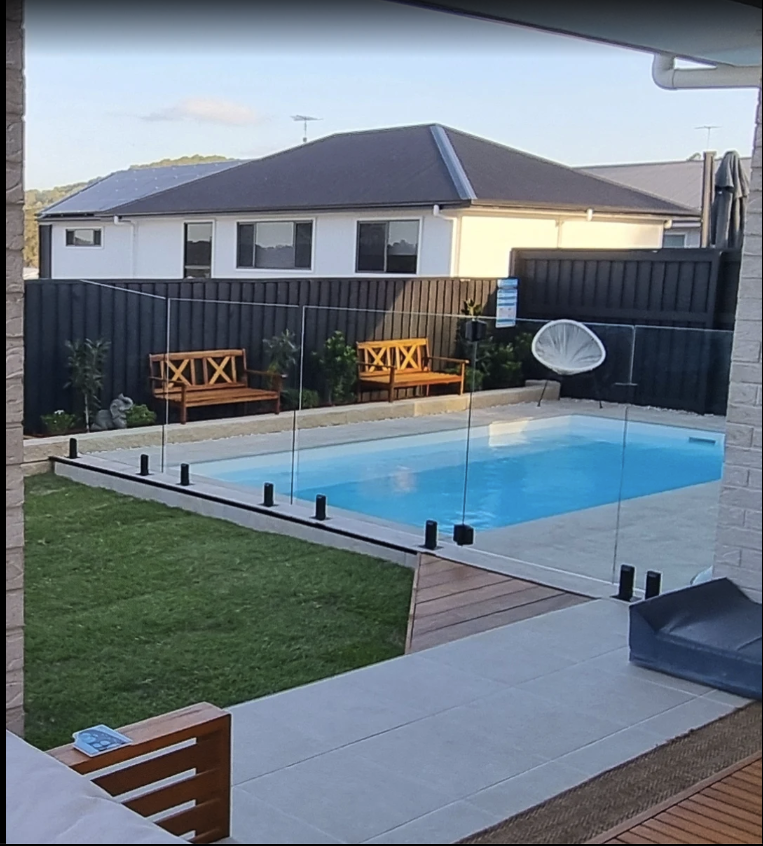 Modern fibreglass pool with timber decking and stone paving