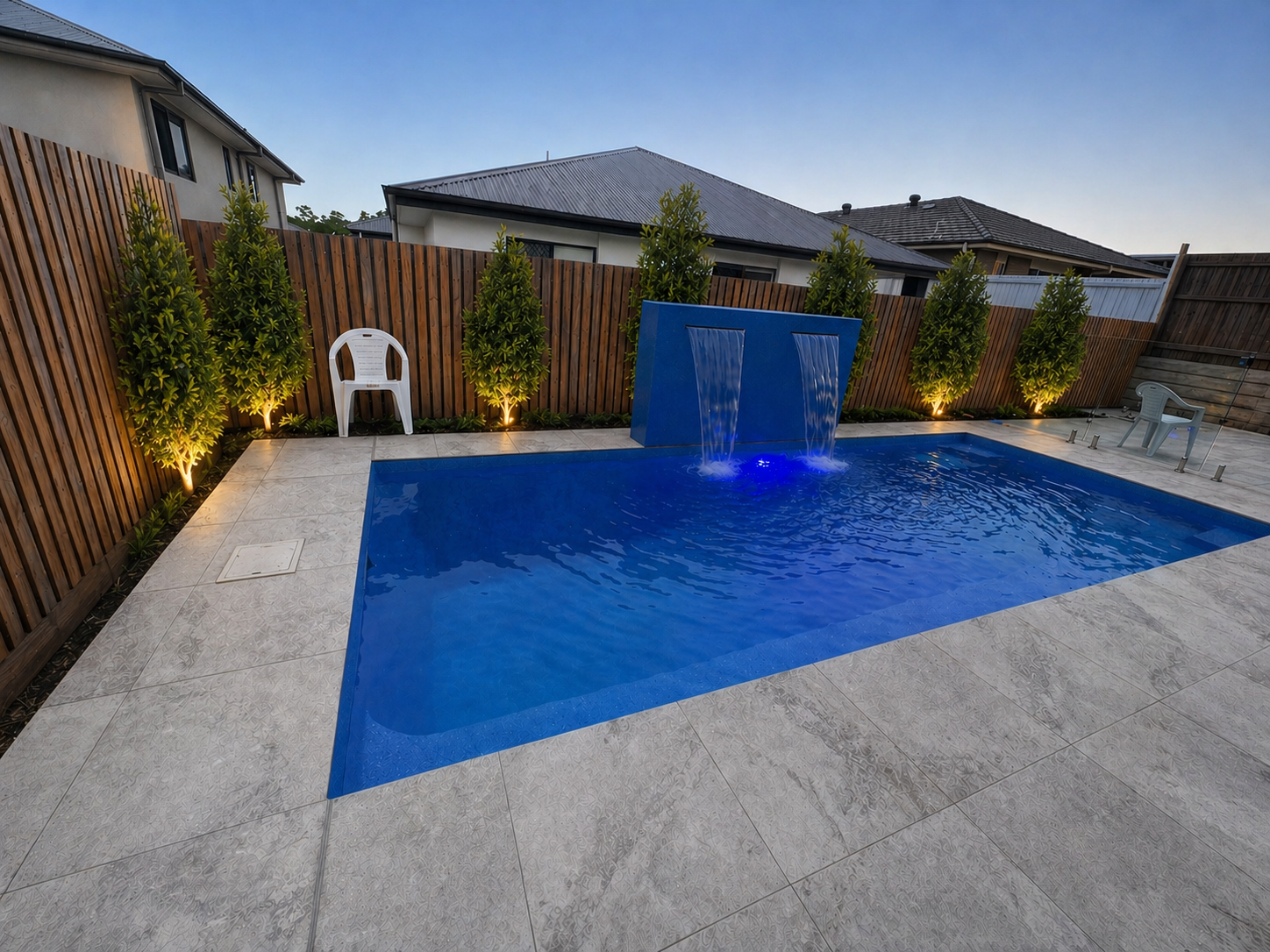 Modern rectangular fibreglass pool with water blade feature wall and LED lighting